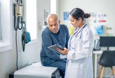 Doctor reviewing test results with middle aged male patient