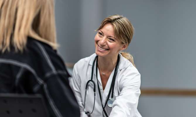 Concierge doctor smiling warmly at a patient.