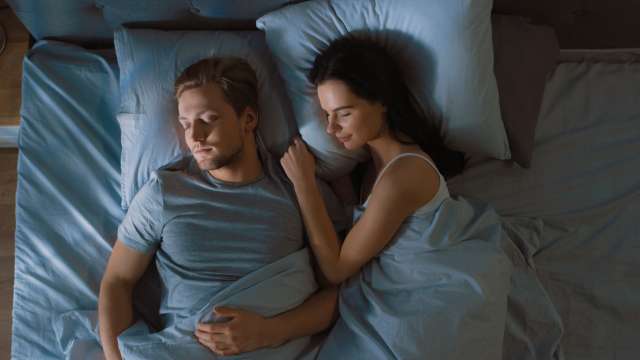 Couple sleeping peacefully in bed.