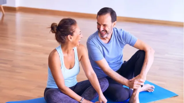 Quiz Start: Man and woman on yoga mat smiling at each other